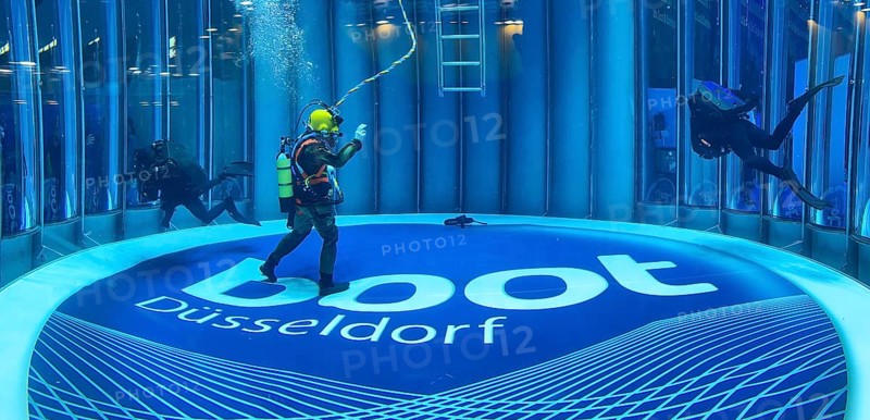 Diver helmet diver from the German Navy with hose for air supply from outside the water during presentation in diving tower at the boot Düsseldorf trade fair, in the background scuba diver, on the ground logo and lettering of Messe boot, Düsseldorf, North Rhine-Westphalia, Germany, Europe