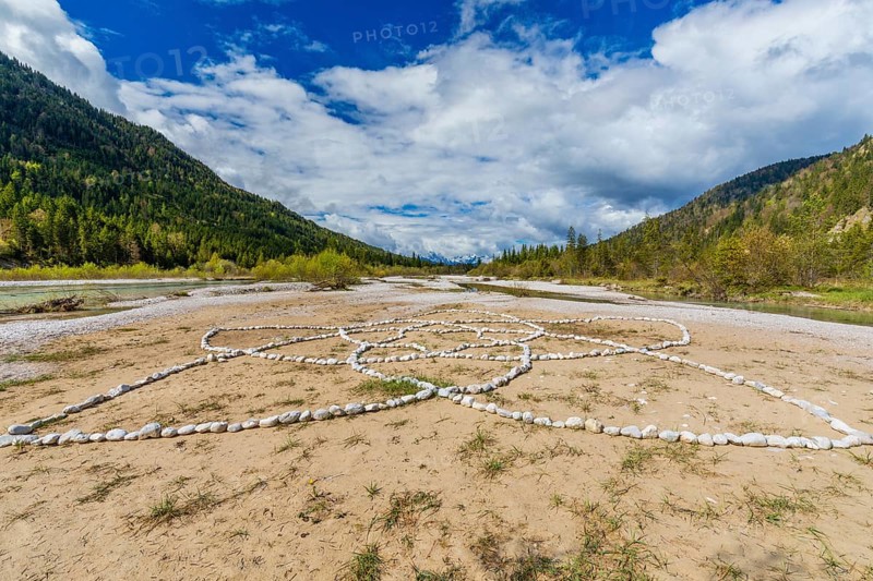 Isar valley nature conservancy area. The wild Isar river flows through its gravel bed past driftwood and entrained trees and bushes . Early morning