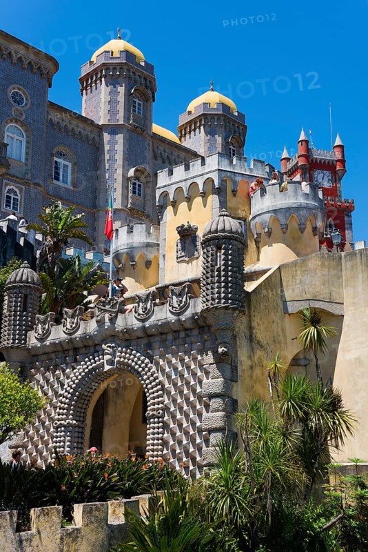 Historic castle with towers, stone structures and plants in the foreground under a blue sky, Palácio Nacional da Pena, Pena National Palace, Sintra, Lisbon, World Heritage Site, UNESCO, Portugal, Europe