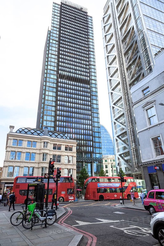 Skyscrapers and red double-decker buses in a busy street scene in the city of London, United Kingdom, Europe