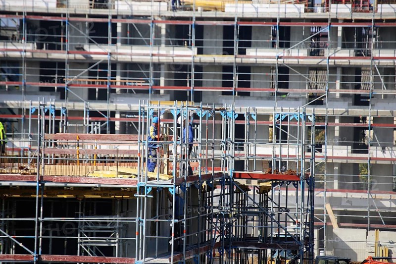 Photo of a large construction site in a newly developed residential area. Several apartment buildings are still under construction