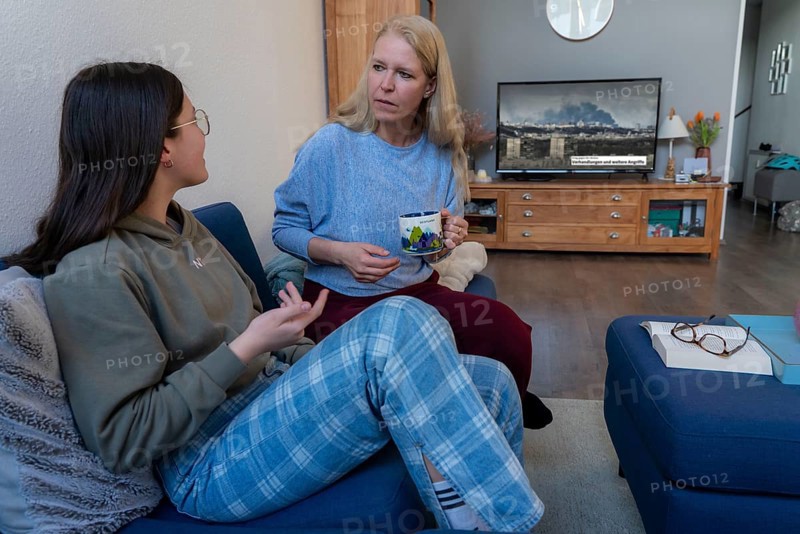 Mother and daughter, teenage, 13 years old, in a confidential conversation, at home, talking about fears, in connection with war, flight
