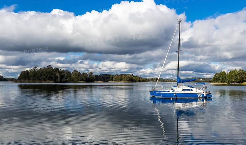 Yacht on Galve lake, Lithuania with blue cloud sky on the background