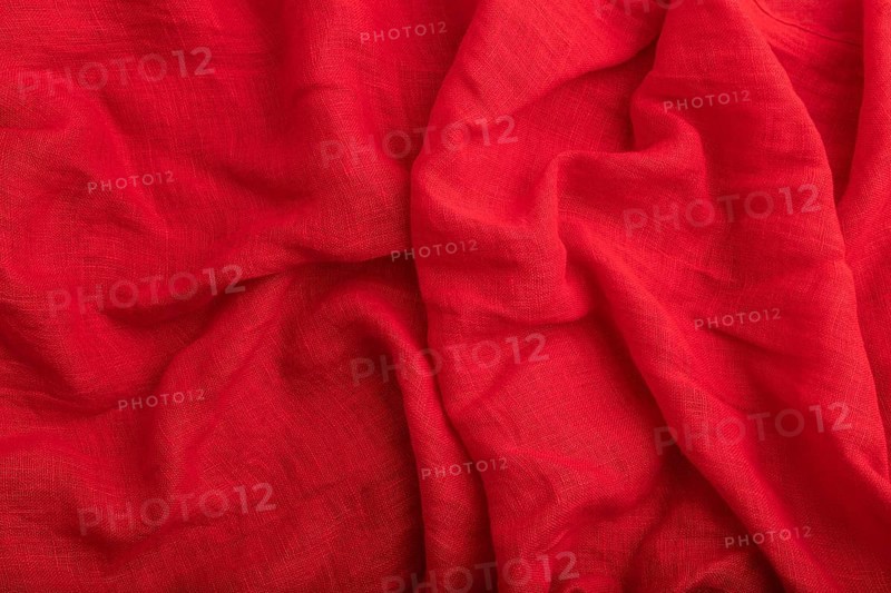 Fragment of red linen tissue. Top view, natural textile background and texture. wave concept, abstract