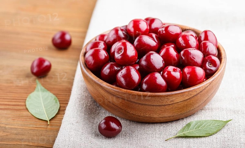 Fresh red sweet cherry in wooden bowl on wooden background. side view, close up