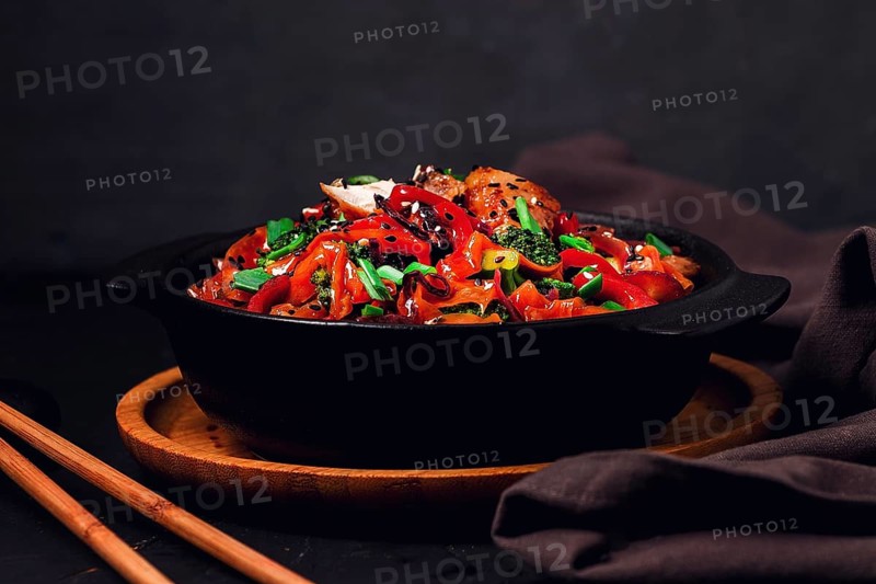 Asian cuisine, teriyaki meat with vegetables, in a cast-iron frying pan, close-up, no people