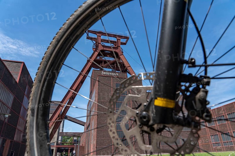 Cycling in the Ruhr region, by bike, e-bike, at the Zollverein Coal Mine Industrial Complex World Heritage Site, double trestle winding tower shaft XII, Essen, North Rhine-Westphalia, Germany, Europe