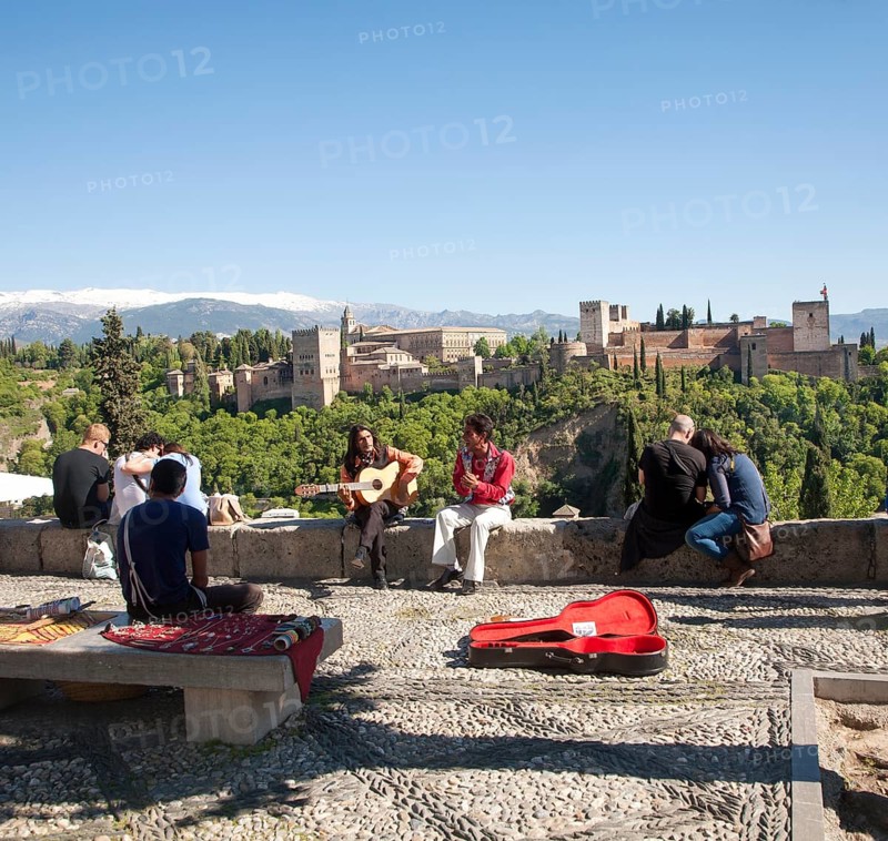 Flamenco musicians play with a backdrop of the snow Sierra Nevada mountains and the Alhambra, Granada, Spain, Europe
