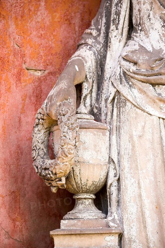 White angel, hand holding a wreath of flowers on an urn, detail of a stone statue, weathered, historic grave monument in the cemeteries on Bergmannstraße, Berlin-Kreuzberg, Berlin, Germany, Europe