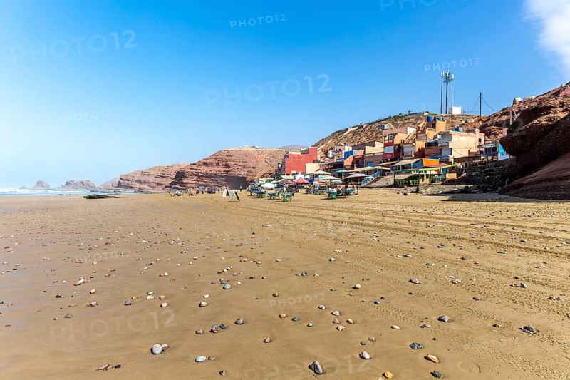 Sandy beach and buildings, Legzira, southern Morocco, north Africa
