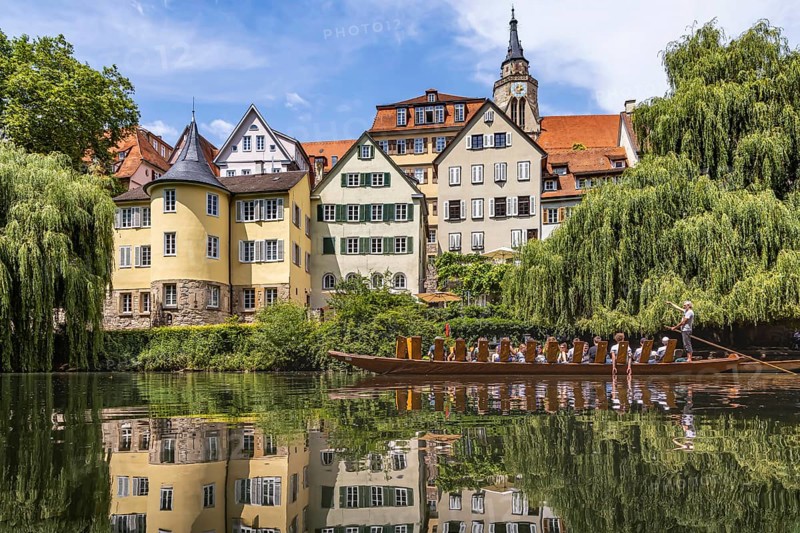 Neckarfront Tübingen with punt on the Neckar. Postcard motif with historic buildings, collegiate church and Hölderlin tower. Tübingen, Baden-Württemberg, Germany, Europe