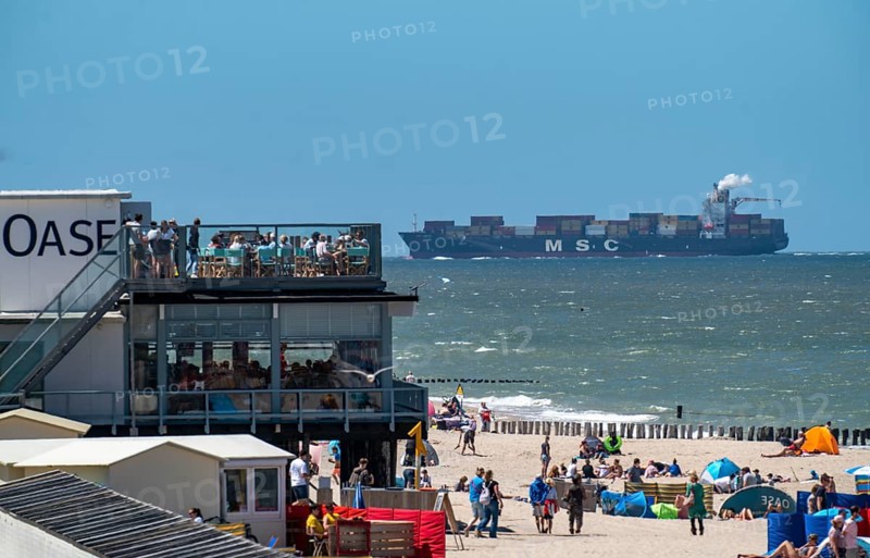 Beach of Domburg, in Zeeland, South Holland, Netherlands, in the background a container freighter of the shipping company MSC, enters the Scheldt, in the direction of the harbour of Antwerp