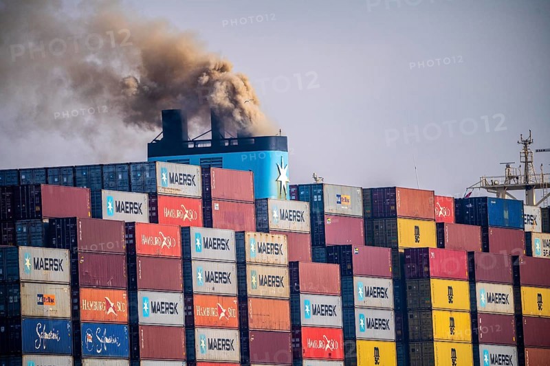 Container freighter Madison Maersk smoking chimneys of the ship's diesel engines, Maasvlakte 2, Rotterdam, Netherlands