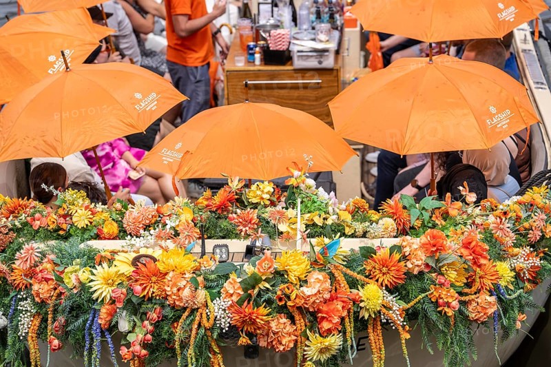 Canal cruise, with flagship organiser, canal boats decorated with flowers, passengers with umbrellas against the summer sun, heat, pier at Centraal Station, excursion boat, Amsterdam Netherlands
