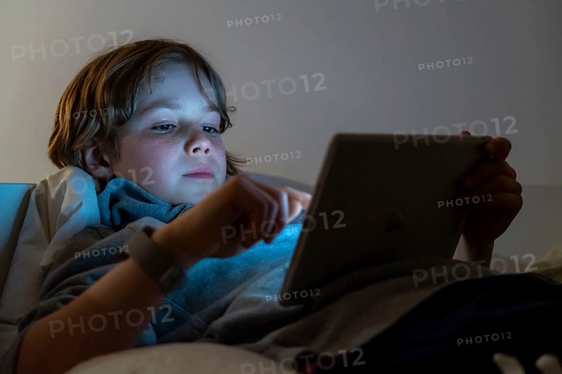A boy plays computer games on a tablet PC