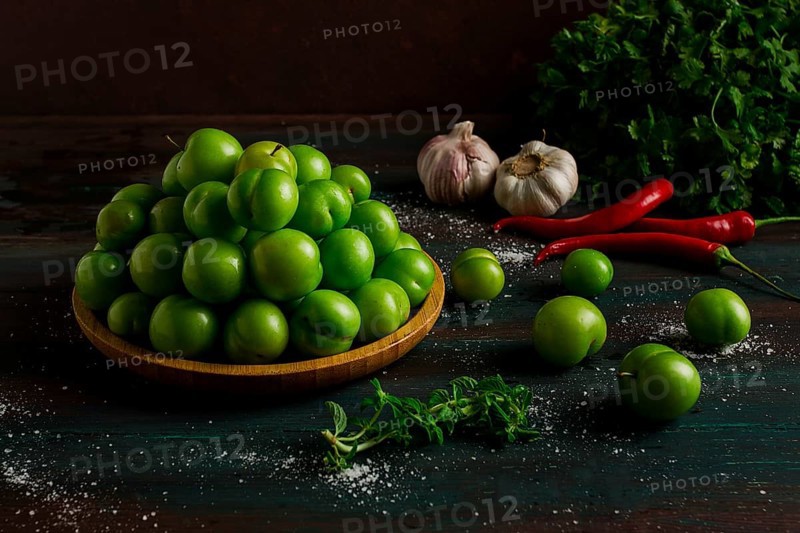 Tkemali, green cherry plum, with ingredients for sauce, cilantro, mint, hot pepper, garlic, on a wooden table, close-up, rustic, food background, no people, selective focus