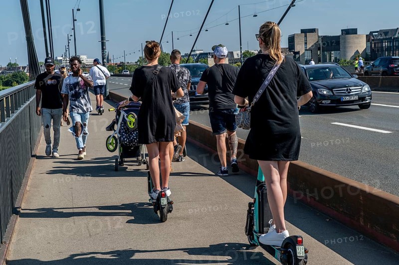 Pedestrians and e-scooters on a pavement, getting close and in each other's way, illegal driving on the pavement by e-scooter users, Düsseldorf, North Rhine-Westphalia