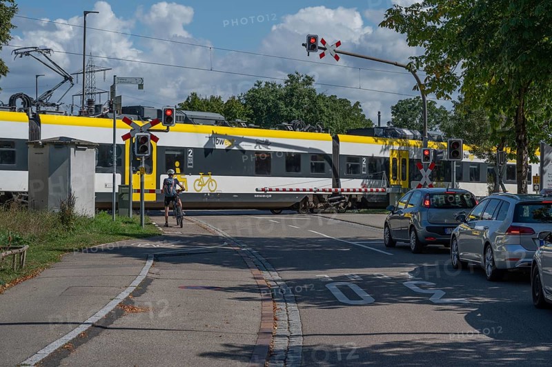 Regional train crossing a level crossing with barriers, Riegel am Kaiserstuhl, Baden-Württemberg, Germany, Europe