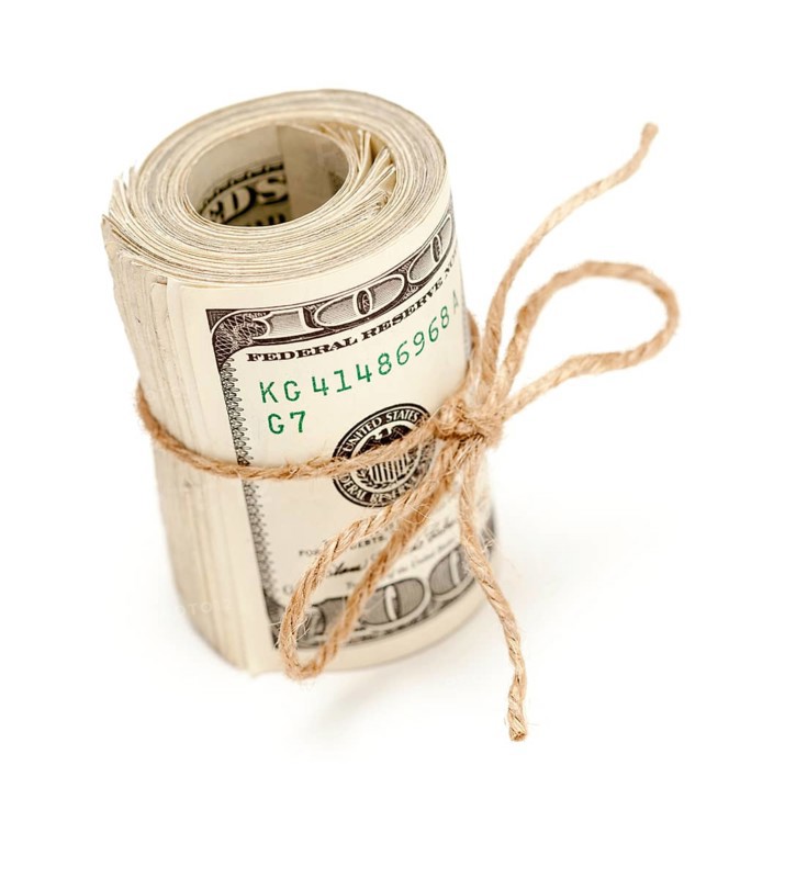 Roll of one hundred dollar bills tied with a jute string isolated on white background