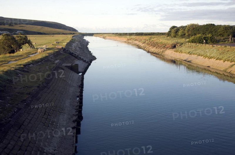 Straightened concrete lined channel of River Cuckmere as it nears its mouth, Exceat, Seaford, East Sussex, England, United Kingdom, Europe