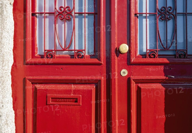 Close-up of vividly red doors on the historical façade in the Ribeira district, Porto, Portugal, Europe