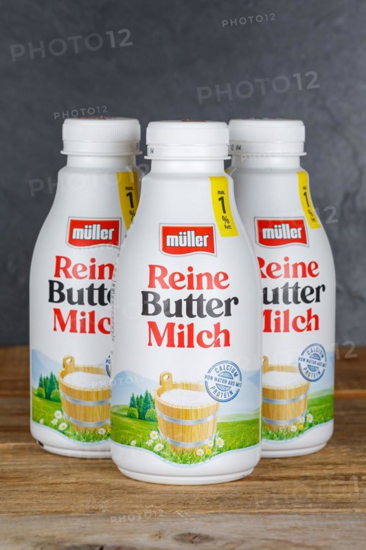Pure buttermilk from the company Theo Müller on wooden board with text free space Copyspace