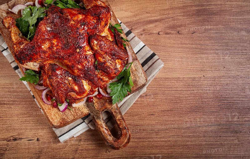 Whole fried chicken, with spices, grilled chicken, on a chopping board, top view, homemade, no people