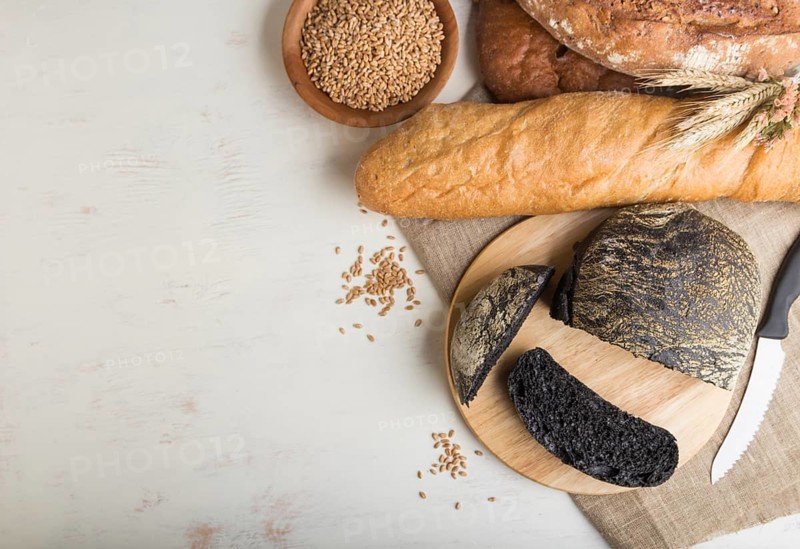 Sliced bread with different kinds of fresh baked bread on a white wooden background. top view, flat lay, copy space