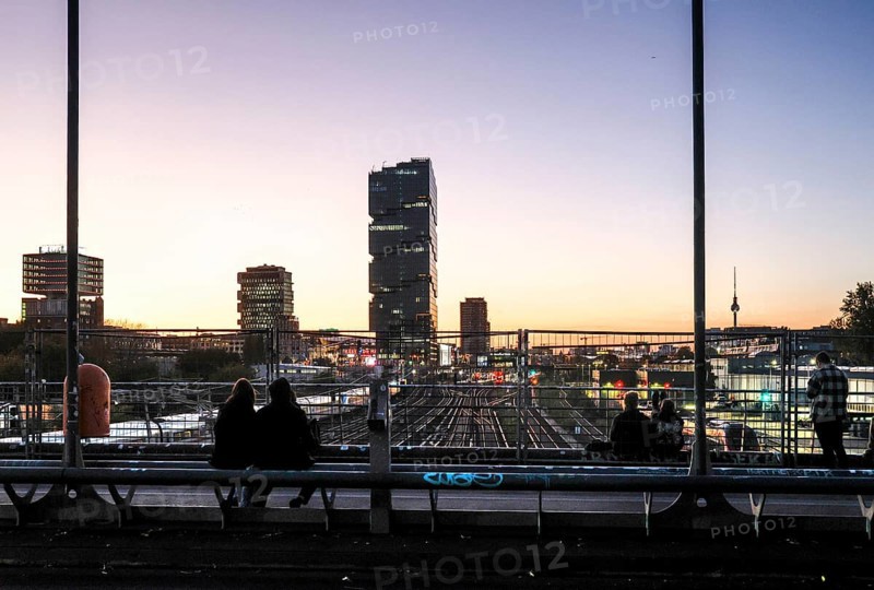 Chilling out at sunset on the Modersohn Bridge, view of railway tracks, trains and the 140 metre high Amazon office tower Edge East Side, Berlin, 23.10.2024., Berlin, Berlin, Germany, Europe