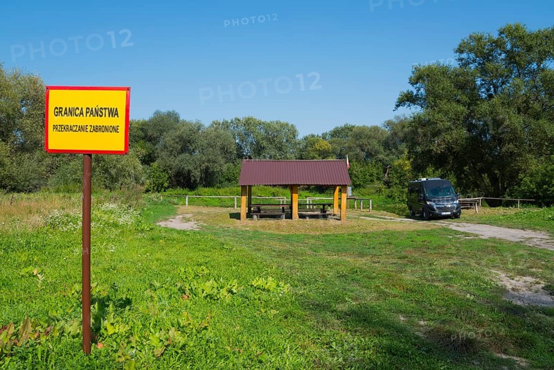 Border sign next to a wooden shelter on a green field with trees and car, motorhome, camper, border with Ukraine, Bereznica, Bereznica, Dorohusk, Horodlo, Horodlo, Hrubieszowski Voivodeship, Lublin Voivodeship, Poland, Europe