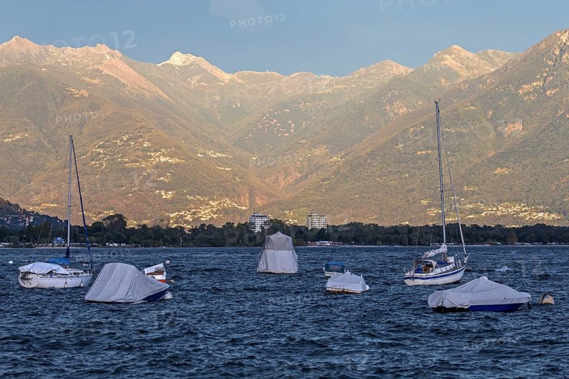 Boats lying in the water, Locarno, Lake Maggiore, surrounding mountains in the evening light, Canton Ticino, Switzerland, Europe