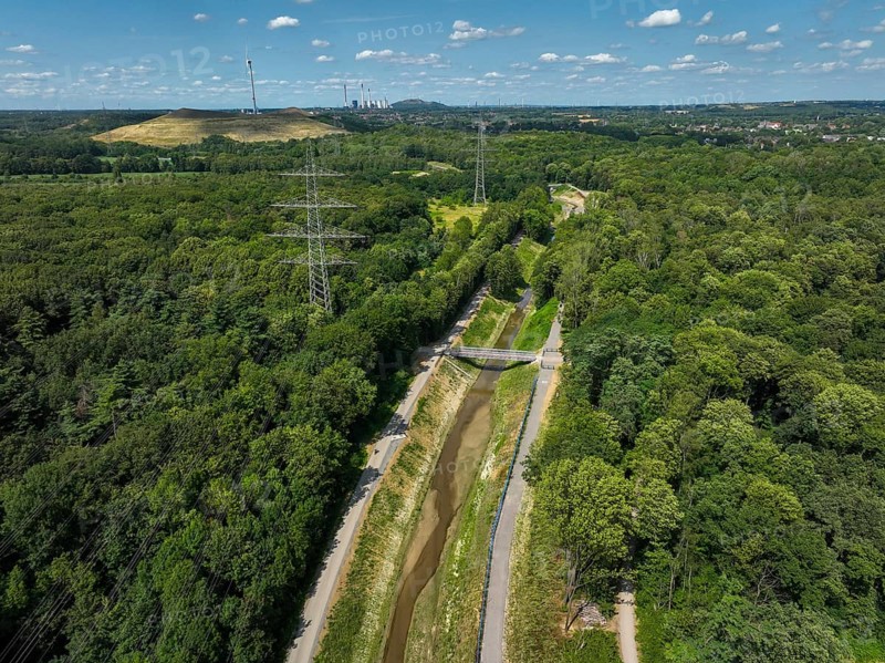 Bottrop, North Rhine-Westphalia, Germany, Renaturalised Boye, the tributary of the Emscher, has been transformed into a near-natural watercourse, flood protection through newly designed flooding areas, the Boye is now free of wastewater following the construction of a parallel sewer, is part of the Emscher river system and thus part of the Emscher conversion, was previously an open, above-ground wastewater channel, mixed water channel with surface water and wastewater. Wind turbine on the Mottbruch spoil tip at the back, Europe