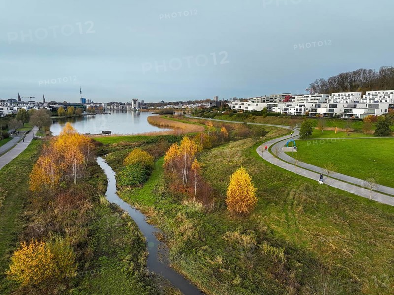 Dortmund, North Rhine-Westphalia, Germany, Phoenix Lake, front of the renaturalised Emscher. The river has been transformed into a near-natural body of water, flood protection and biodiversity through newly designed floodplains. A former industrial wasteland of 99 hectares was transformed into residential, work and leisure areas and 24 hectares of lake surface. In the event of heavy rainfall, the lake acts as a rainwater retention basin. Following the construction of a parallel sewer, the Emscher is now free of wastewater, having previously been an open, above-ground wastewater sewer, combined sewer with surface water and wastewater. The Phoenix Lake, a showcase project for structural change, is an artificial lake on the site of the former Phönix Ost steelworks in Dortmund's Hörde district, Europe