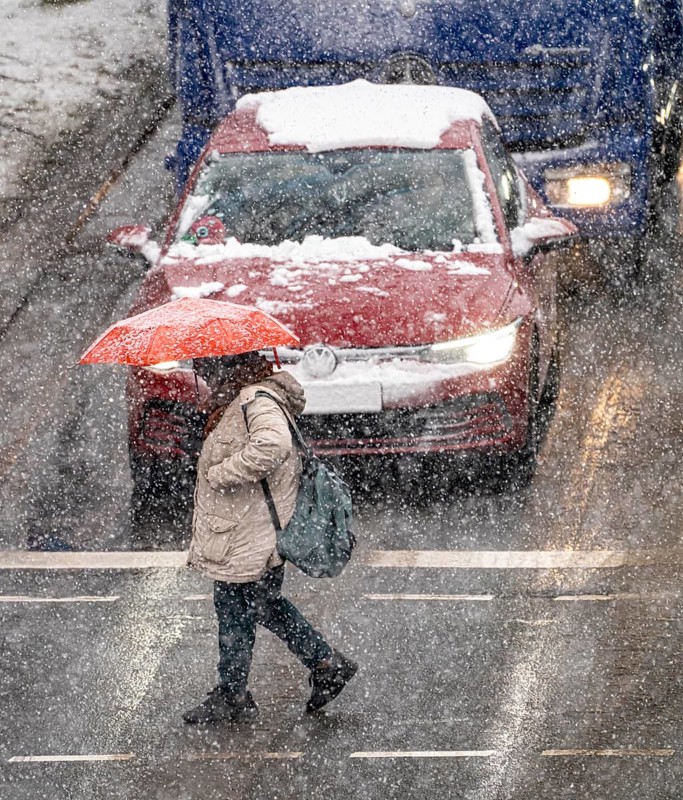 Winter weather, heavy snowfall, city centre traffic, Alfredstraße, B224, in Essen, person with umbrella traffic light in snowstorm, North Rhine-Westphalia, Germany, Europe