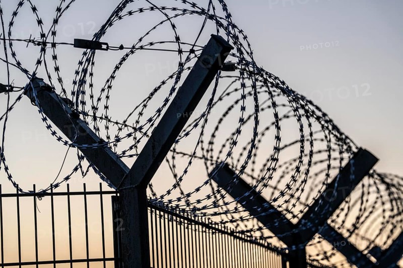 Symbolic image security, S-wire rolls, NATO wire, on a fence top, demarcation of a property, prevention of unauthorised access, strip steel wire with sharp blades
