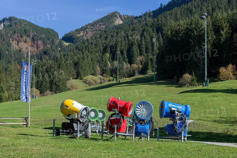 Snow cannons stand on a green meadow in front of a sunny mountain landscape, Schwangau, Ostallgäu, Allgäu, Swabia, Upper Bavaria, Bavaria, Germany, Europe