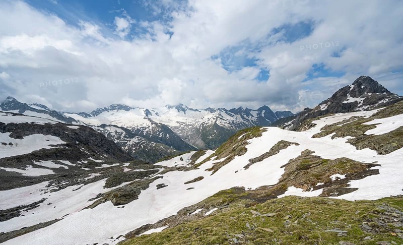 Picturesque mountain landscape with snow remains, mountain peaks with snow and glacier Schwarzensteinkees, Hornkees and Waxeggkees, summit Schwarzenstein, Hornspitzen and Turnerkamp, valley Zemmgrund with Zemmbach, Berliner Höhenweg, Zillertal Alps, Tyrol, Austrianm