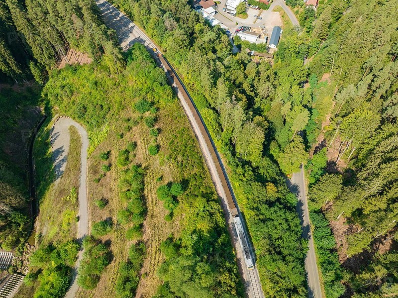 Railway line through dense forest from a bird's eye view, track construction, rail delivery for Hermann Hessebahn, Calw, Black Forest, Germany, Europe