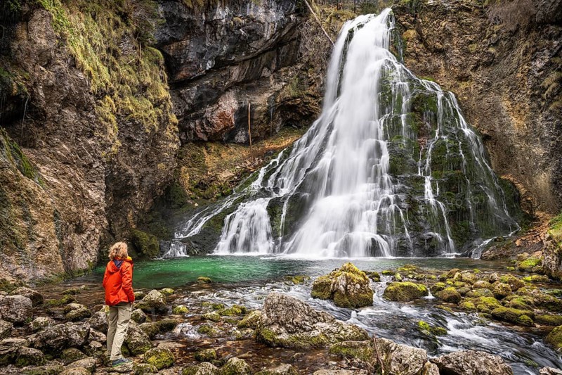 A hiker at the Gollinger waterfall (Schwarzbachfall, Schwarzenbachfall) in autumn. Rocks with moss. Tennengau, Salzburger Land, Upper Austria, Austria, Europe