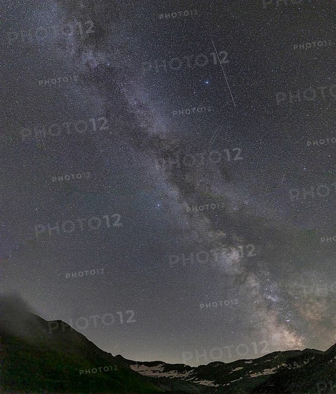 Nocturnal starry sky over the Furka Pass in the Swiss Alps. The night photograph shows the stars of the Milky Way and shooting stars. Obergoms, Valais, Switzerland, Europe