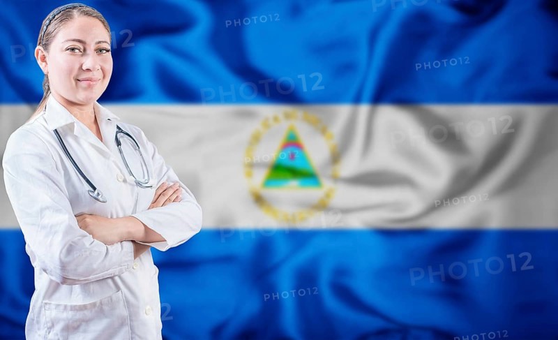 Doctor with crossed arms on Nicaragua flag background. Doctor with stethoscope on Nicaraguan flag. Nicaragua Health and Care concept