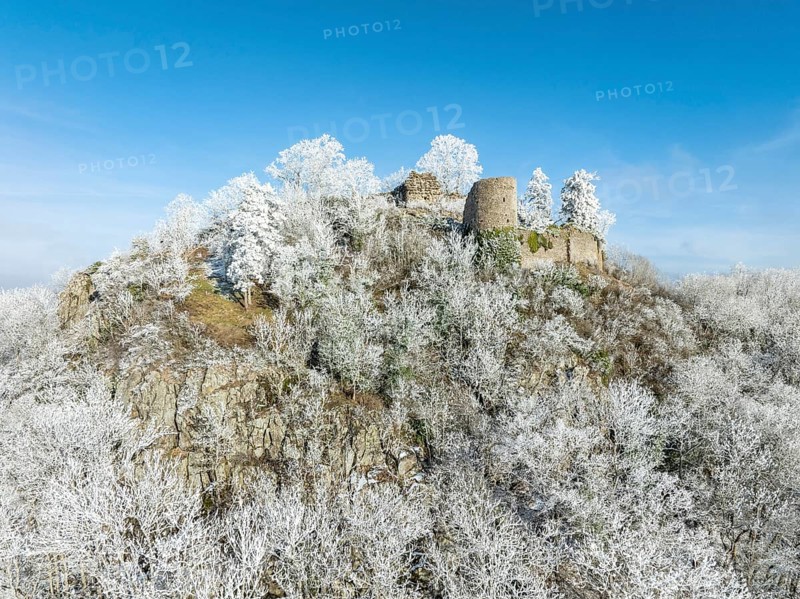 Aerial view of the snow-covered Hegau volcano Mägdeberg, with remains of a castle wall, surrounded by frosty trees in a winter landscape, district of Constance, Baden-Württemberg, Germany, Europe
