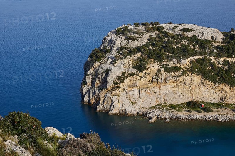 Steep rocky coast with calm, blue water and green vegetation under a clear sky, Anthony Quinn Bay, Vagies Bay, Rhodes, Dodecanese, Greek Islands, Greece, Europe