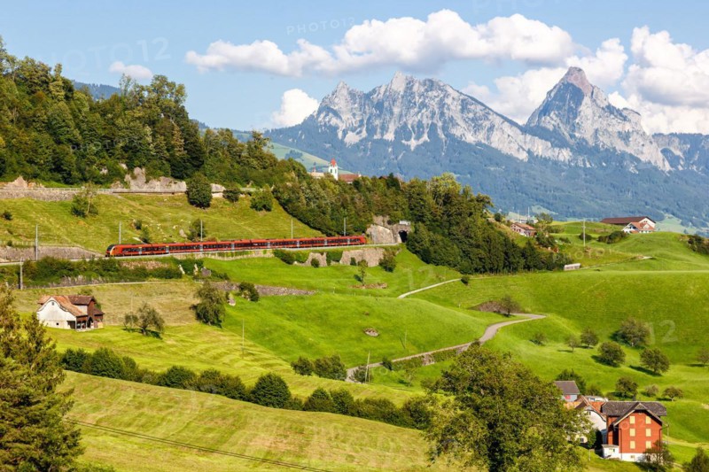 Railway passenger train of the type Stadler Flirt of the Südostbahn on the mountain Großer Mythen in the Alps in Arth, Switzerland, Europe