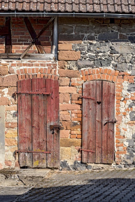 Historic farmhouse around 1800, half-timbered façade, sandstone, natural stone, brick, weathered wooden doors to stable and loo, with heart, idyllic, romantic, Nidda, Vogelsberg, Wetterau, Hesse, Germany, Europe