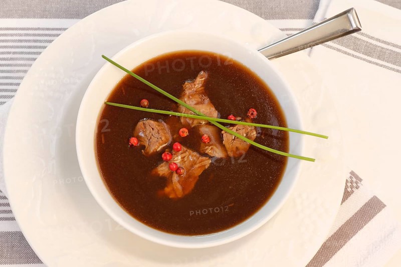 Southern German cuisine, oxtail soup with red pepper in a soup plate, bound soup, meat soup, chives, soup cup, traditional cuisine, speciality, food photography, studio, Germany, Europe