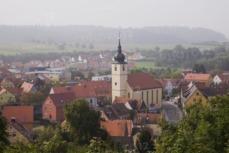 Medieval town of Feuchtwangen with clock tower and buildings with traditional terracotta ceramic tiled ceramic roofs in late summer, Germany, Europe