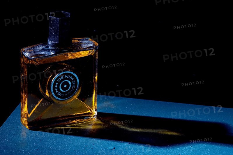 Bottle with aftershave in dark light, elegant style with blue background