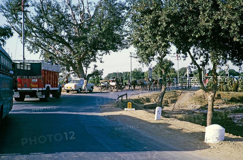 Fahrzeuge, die an einem Bahnübergang warten, ländliches Indien, wahrscheinlich Uttar Pradesh im Jahr 1964