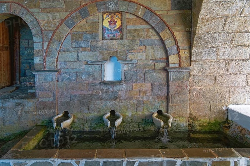 Ancient stone fountain with three water sources, marble basin and mural below the Panagía church, Mesochori, Karpathos, South Aegean, Greece, Europe